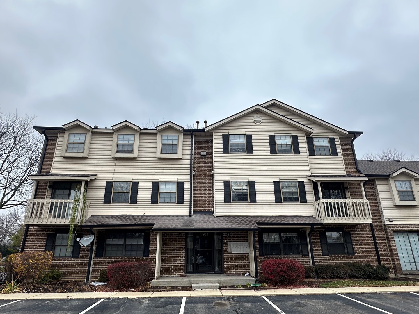 a front view of a residential apartment building with a yard and a garage