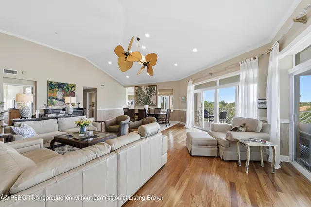 a living room with furniture wooden floor and a large window