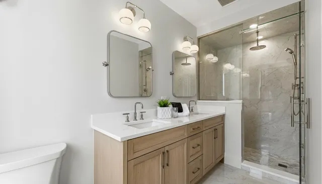 a bathroom with a double vanity sink mirror and shower