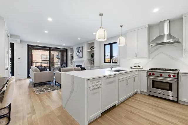 a large kitchen with a sink stainless steel appliances and cabinets