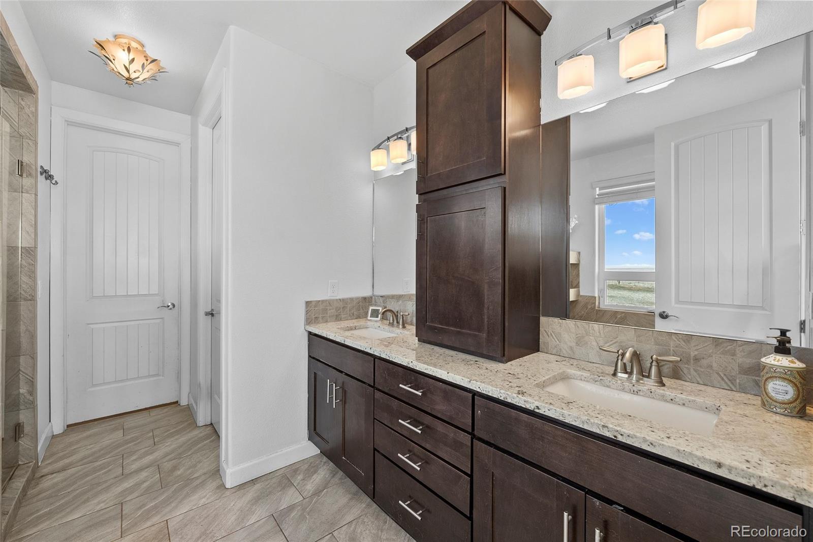 7600 Patrick Trail Elizabeth, CO 80107 - Photo 14 of 45 a bathroom with a granite countertop sink and a mirror