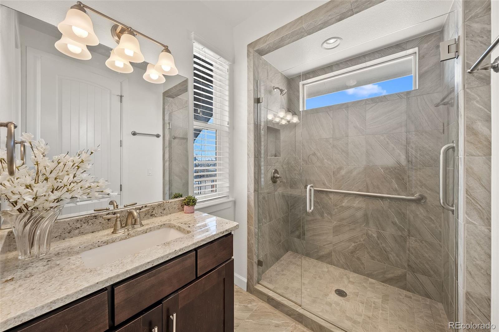 7600 Patrick Trail Elizabeth, CO 80107 - Photo 18 of 45 a bathroom with a granite countertop sink a mirror and a shower