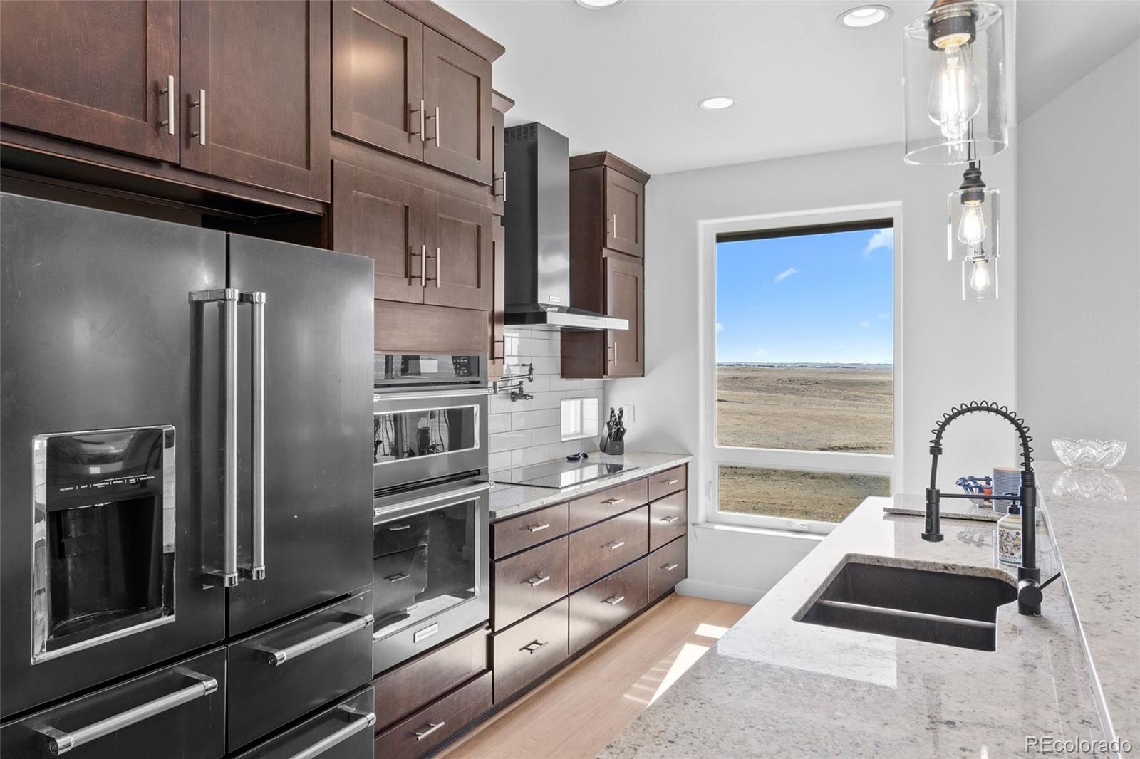 7600 Patrick Trail Elizabeth, CO 80107 - Photo 6 of 45 a kitchen with stainless steel appliances granite countertop a refrigerator and a sink