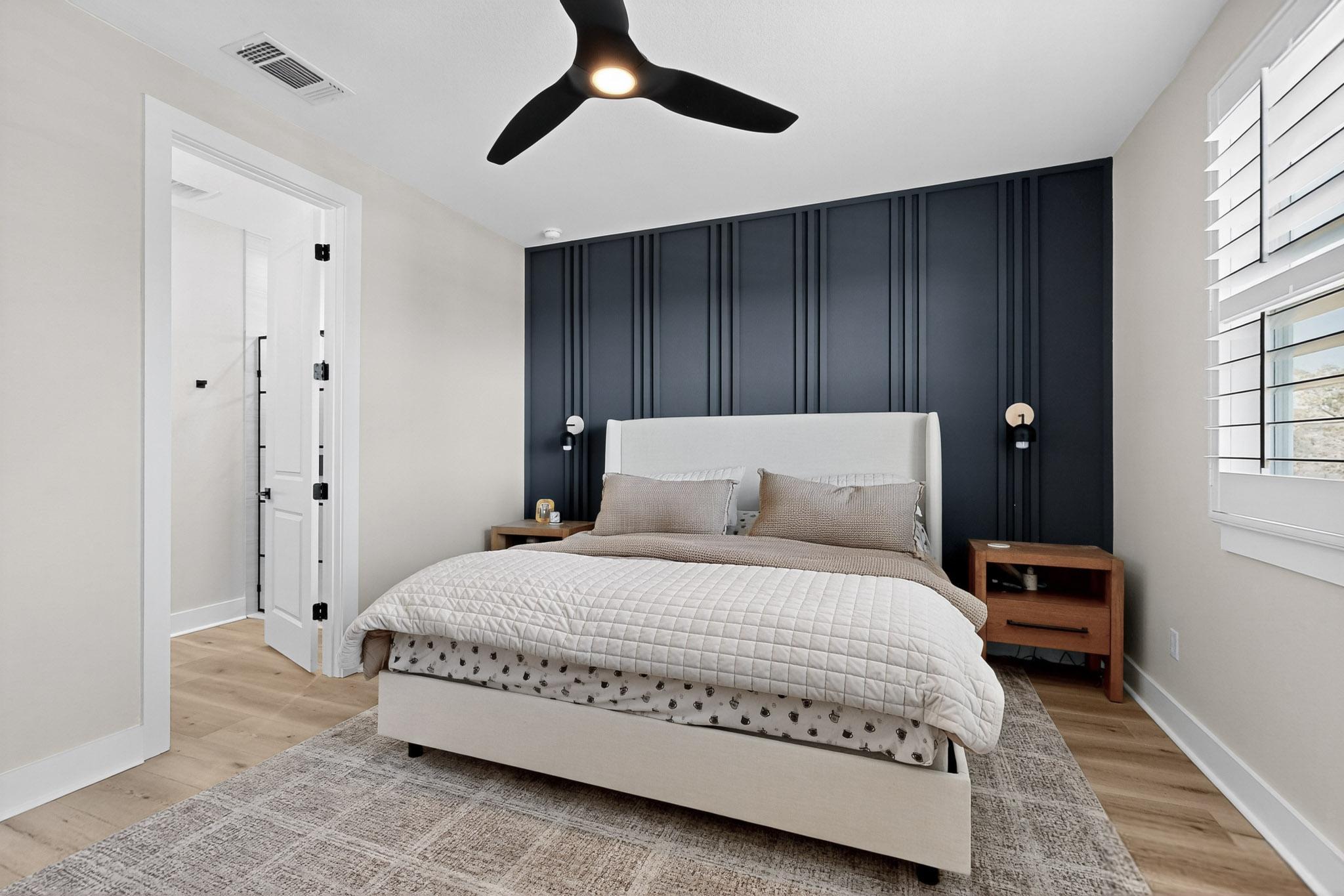 473 Bauer Loop Liberty Hill, TX 78642 - Photo 17 of 38 Primary Bedroom with an accent wall, light wood finished floors, and ceiling fan