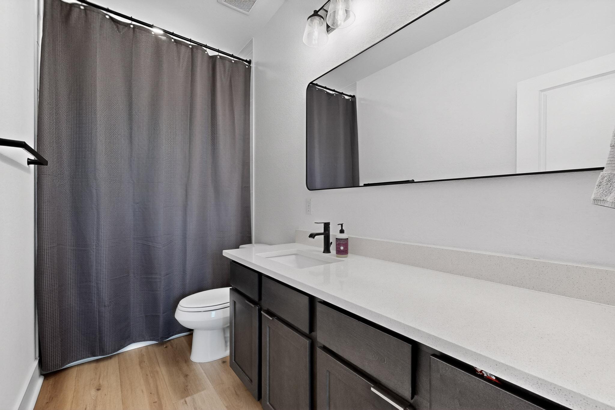 473 Bauer Loop Liberty Hill, TX 78642 - Photo 24 of 38 Bathroom with light wood-style floors, curtained shower, and vanity