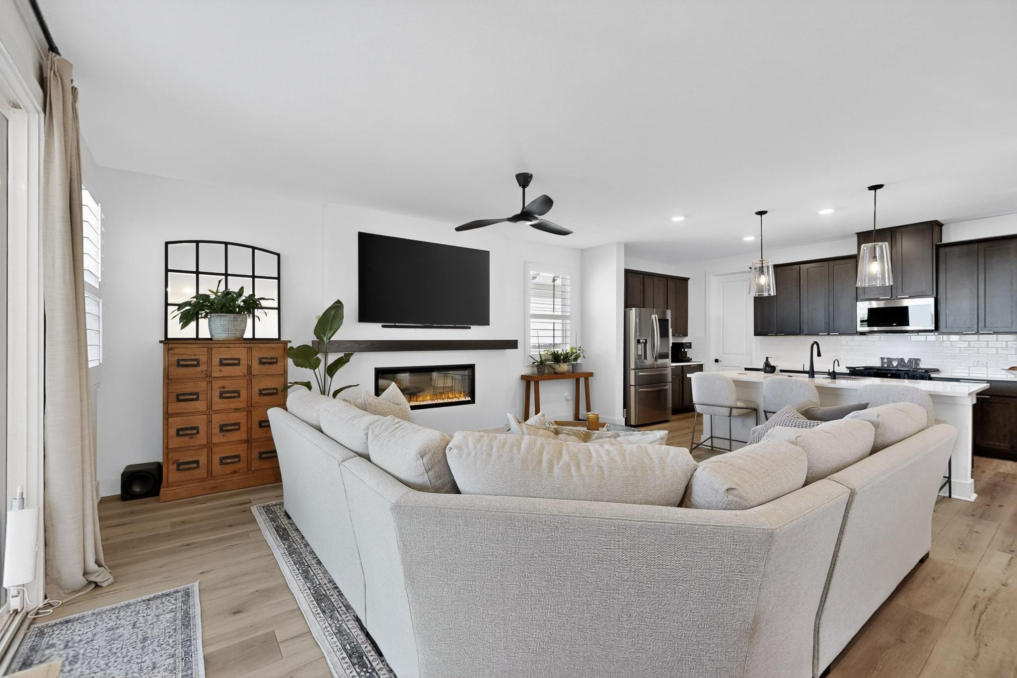 473 Bauer Loop Liberty Hill, TX 78642 - Photo 4 of 38 Living area with a glass covered fireplace, a ceiling fan, recessed lighting, and light wood-type flooring