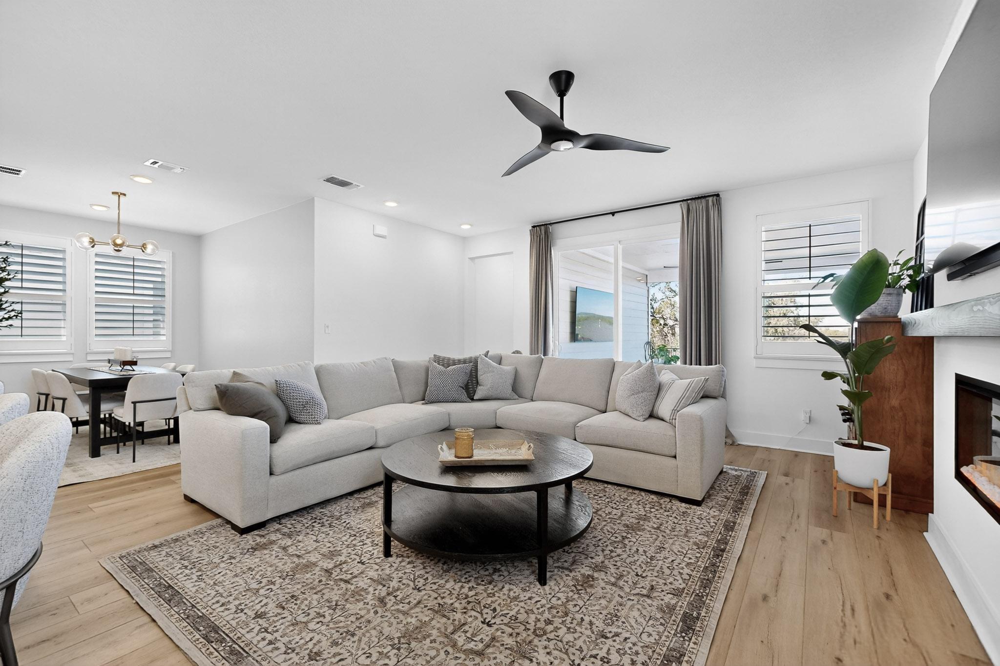 473 Bauer Loop Liberty Hill, TX 78642 - Photo 6 of 38 Living room with a glass covered fireplace, plenty of natural light, light wood-style floors, and recessed lighting