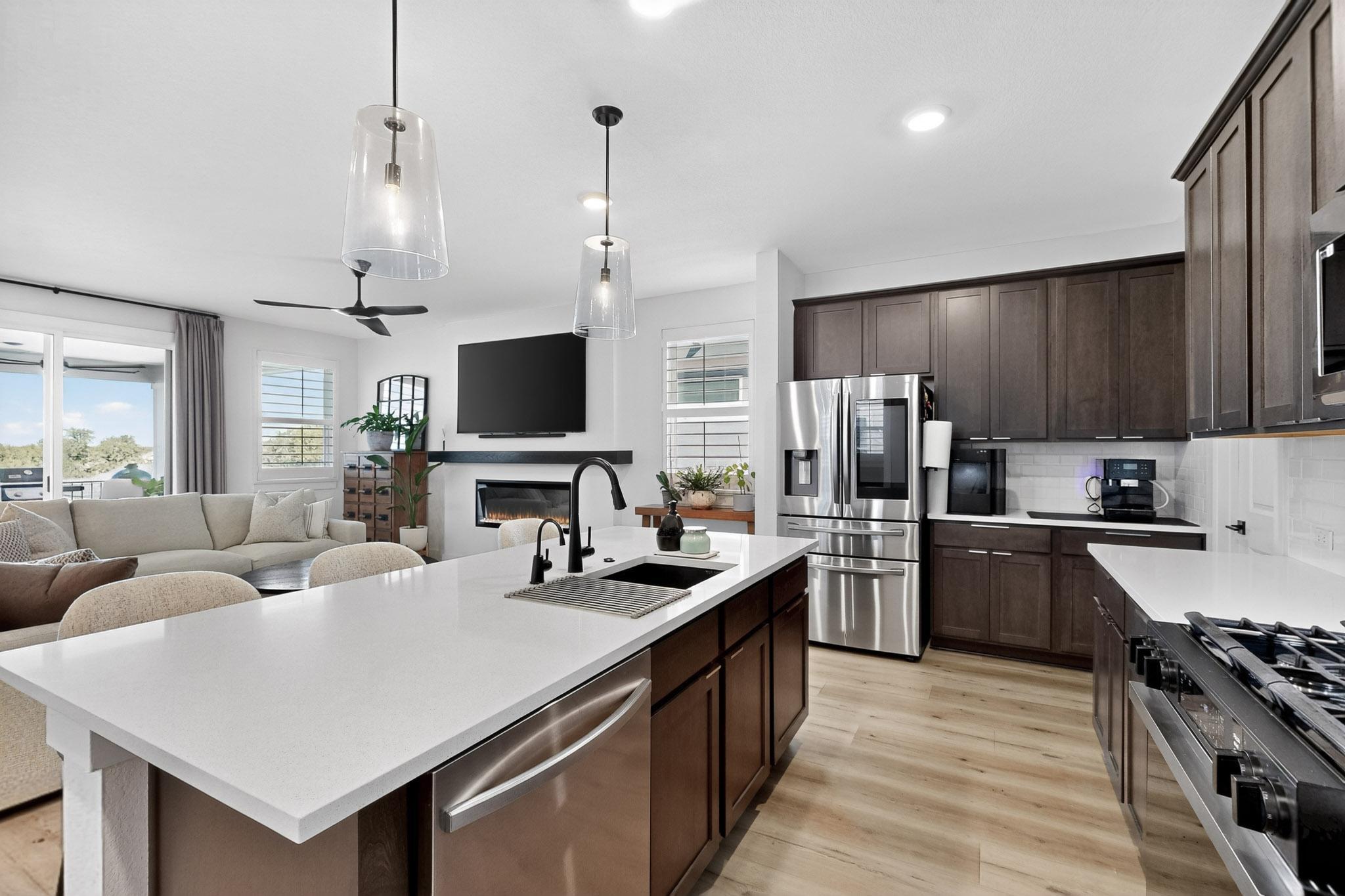 473 Bauer Loop Liberty Hill, TX 78642 - Photo 38 of 38 Kitchen featuring espresso cabinetry, stainless steel appliances, open floor plan, decorative light fixtures, and recessed lighting