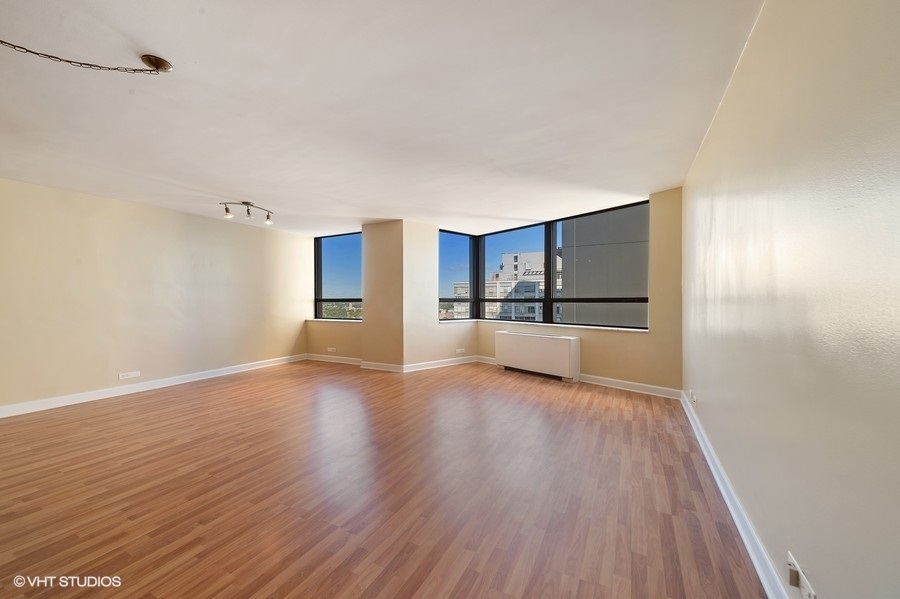 5701 North Sheridan Road, Unit 21H Chicago, IL 60660 - Photo 2 of 14 a view of a kitchen with a fridge and wooden floor