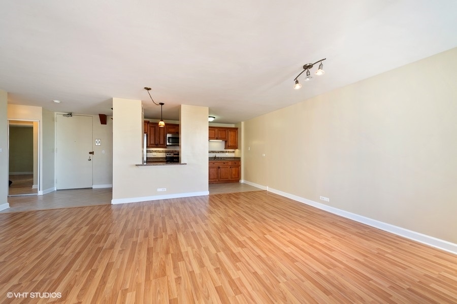 5701 North Sheridan Road, Unit 21H Chicago, IL 60660 - Photo 4 of 14 wooden floor in an empty room with a window