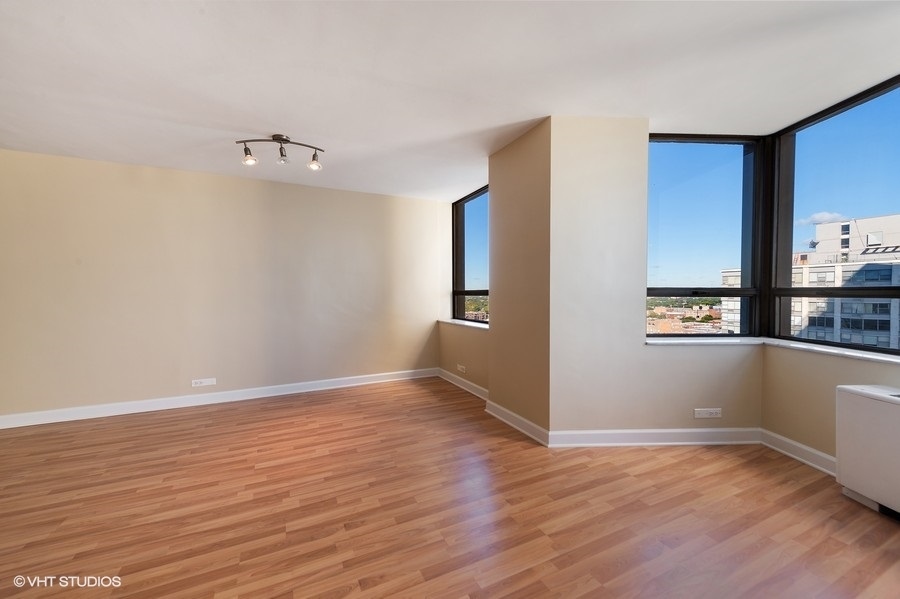 5701 North Sheridan Road, Unit 21H Chicago, IL 60660 - Photo 5 of 14 a view of an empty room with window and wooden floor