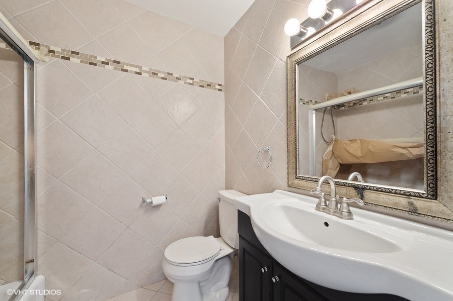 5701 North Sheridan Road, Unit 21H Chicago, IL 60660 - Photo 9 of 14 a bathroom with a sink toilet and shower