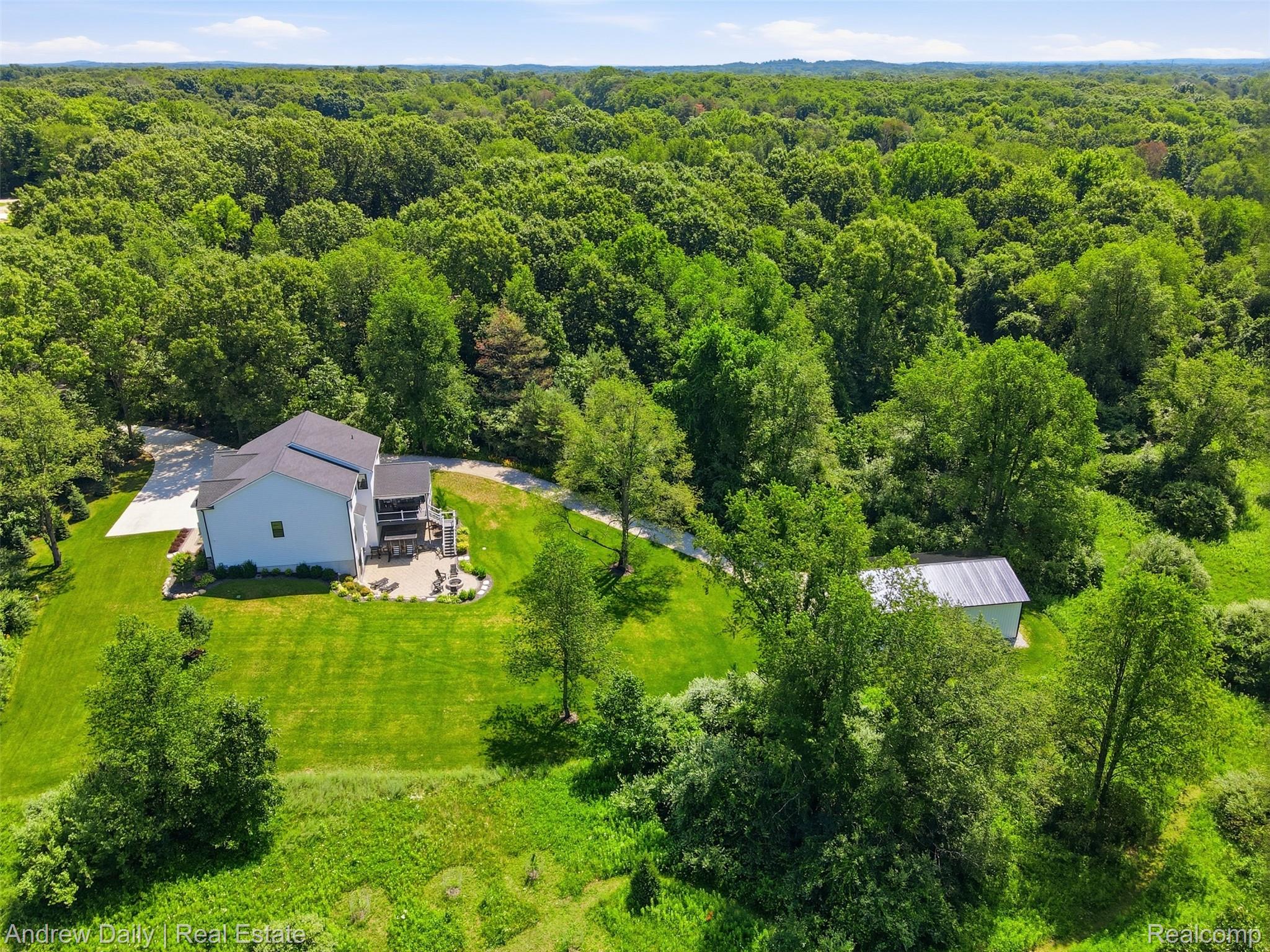 4661 Spears Road Pinckney, MI 48169 - Photo 51 of 56 Expansive property featuring a contemporary residence, a detached auxiliary building, and a vast treed landscape