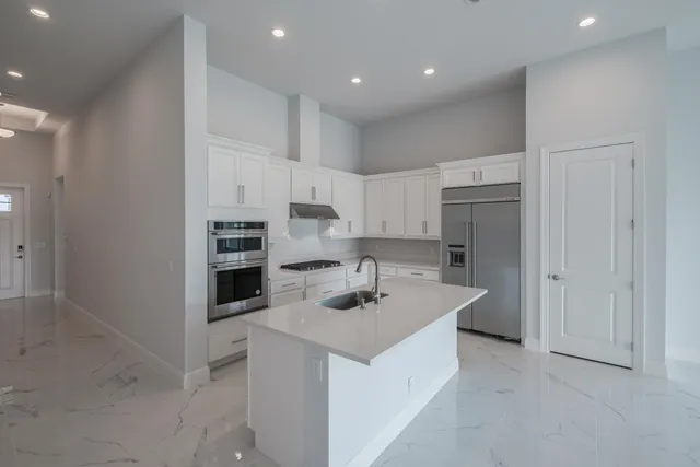 a kitchen that has a cabinets a sink and a stove top oven