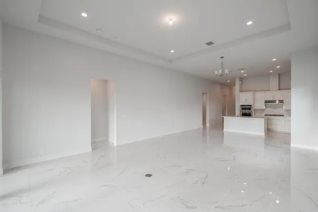 a view of a big room with kitchen and windows