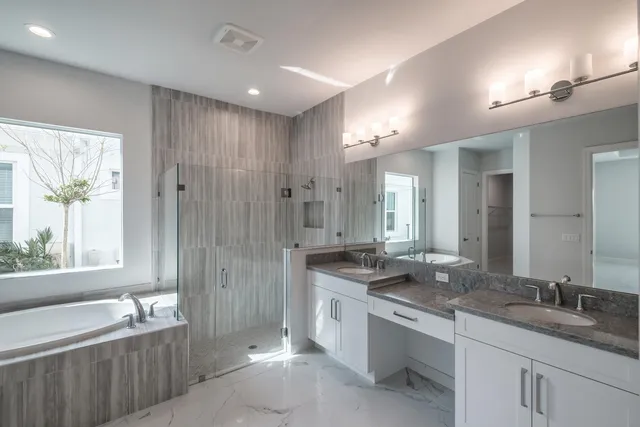 a spacious bathroom with a granite countertop tub sink and mirror