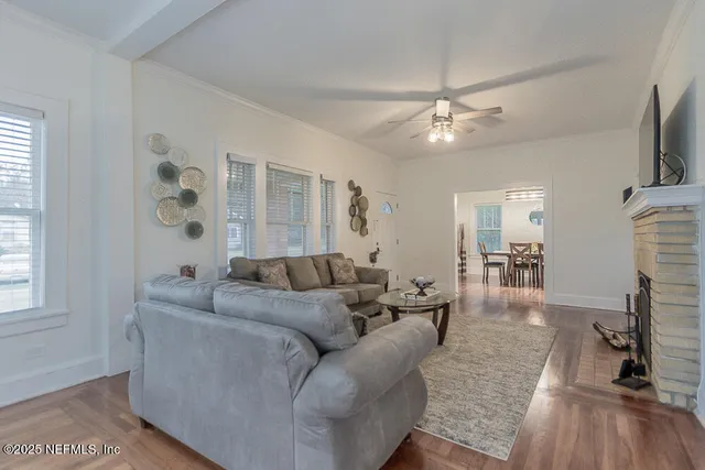 a living room with furniture a ceiling fan and a window