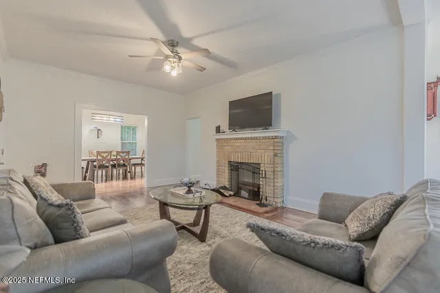 a living room with furniture a fireplace and a flat screen tv
