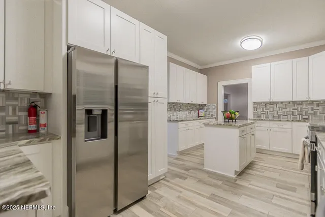 a kitchen with white cabinets and white appliances