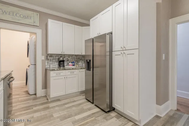 a kitchen with white cabinets and refrigerator