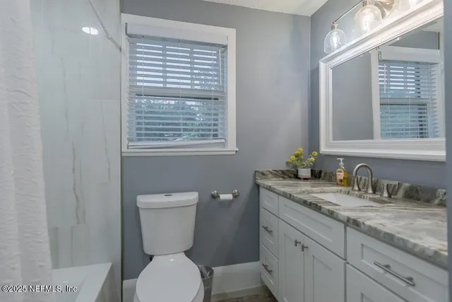 a bathroom with a toilet a sink and mirror