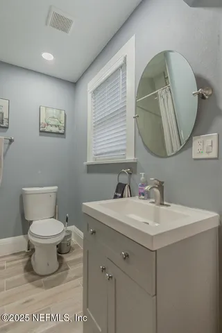a bathroom with a toilet sink and mirror