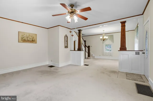 a living room with furniture a flat screen tv and a chandelier