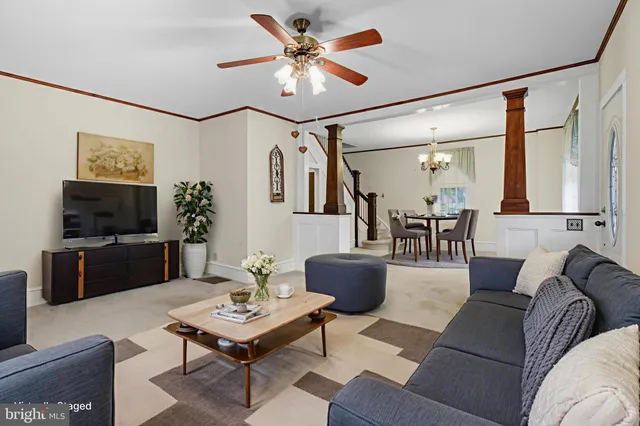 an empty room with chandelier fan and windows