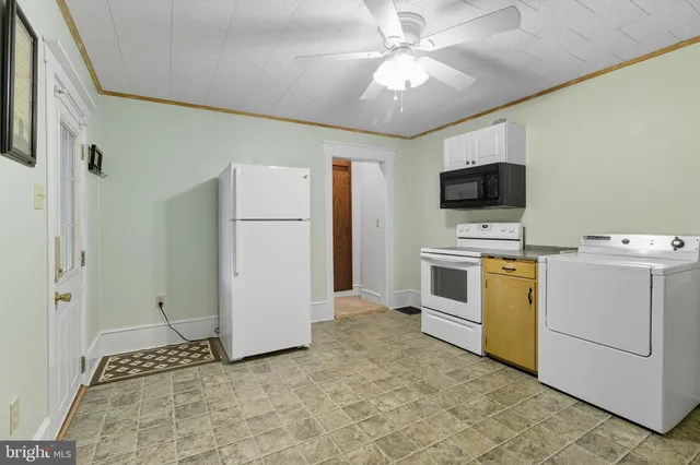a living room with a couch and a refrigerator