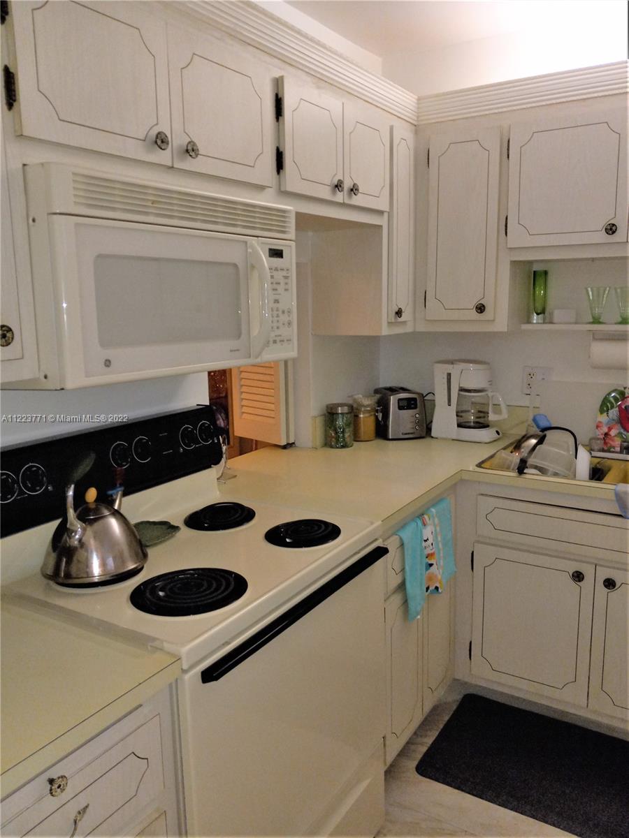 2223 Park Lane, Unit 211 Hollywood, FL 33021 - Photo 4 of 21 a kitchen with white cabinets and sink