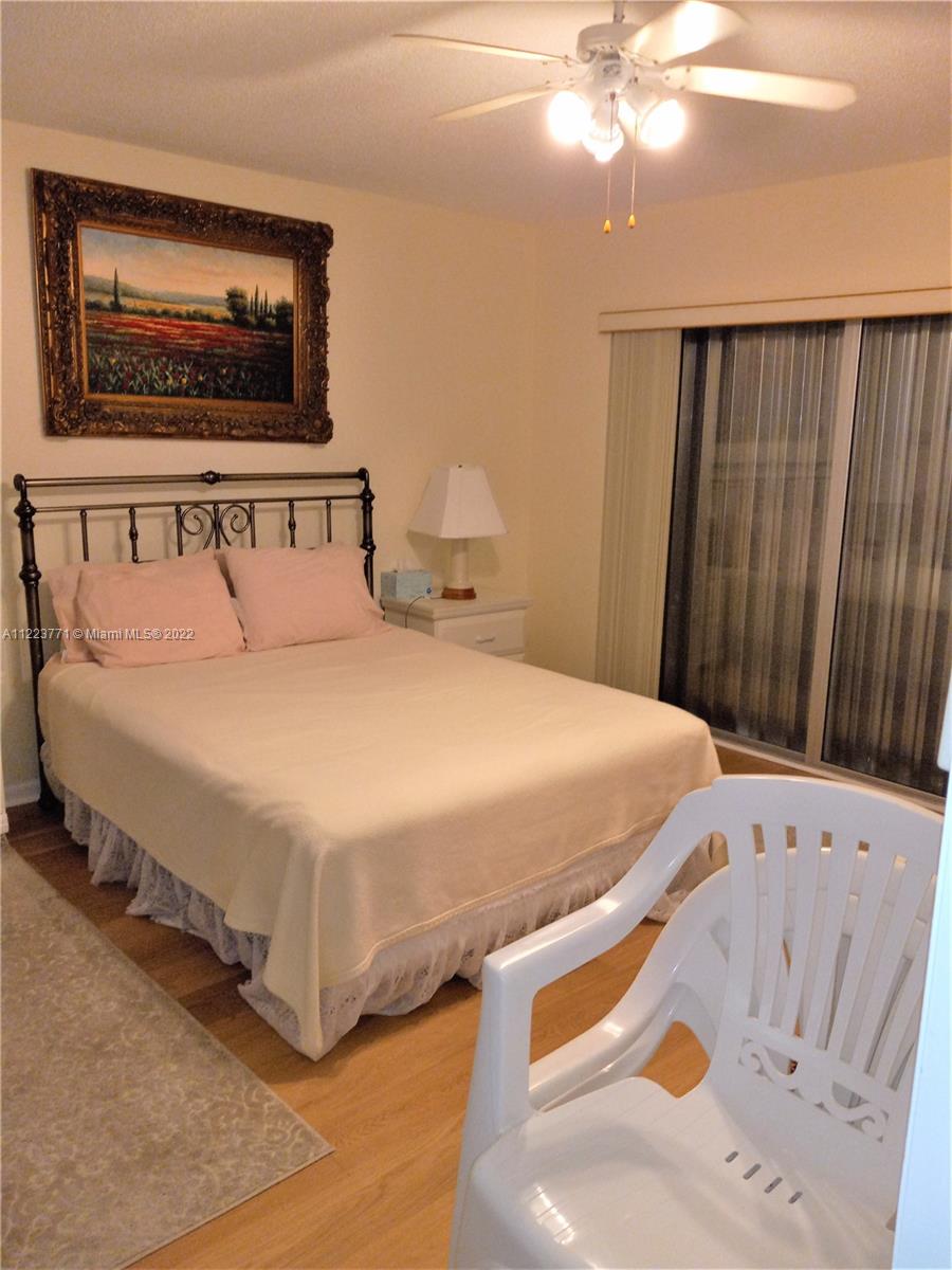 2223 Park Lane, Unit 211 Hollywood, FL 33021 - Photo 7 of 21 a bedroom with a bed and a chandelier