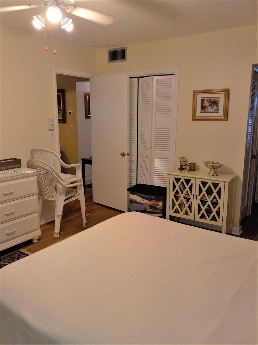 2223 Park Lane, Unit 211 Hollywood, FL 33021 - Photo 8 of 21 a bedroom with a bed and a chair