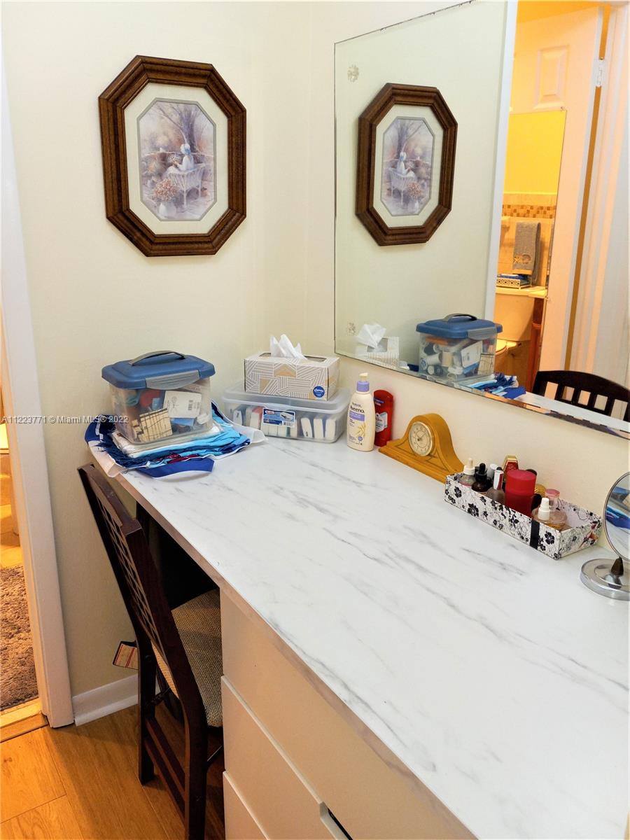 2223 Park Lane, Unit 211 Hollywood, FL 33021 - Photo 10 of 21 a room with a clock on the wall and a table