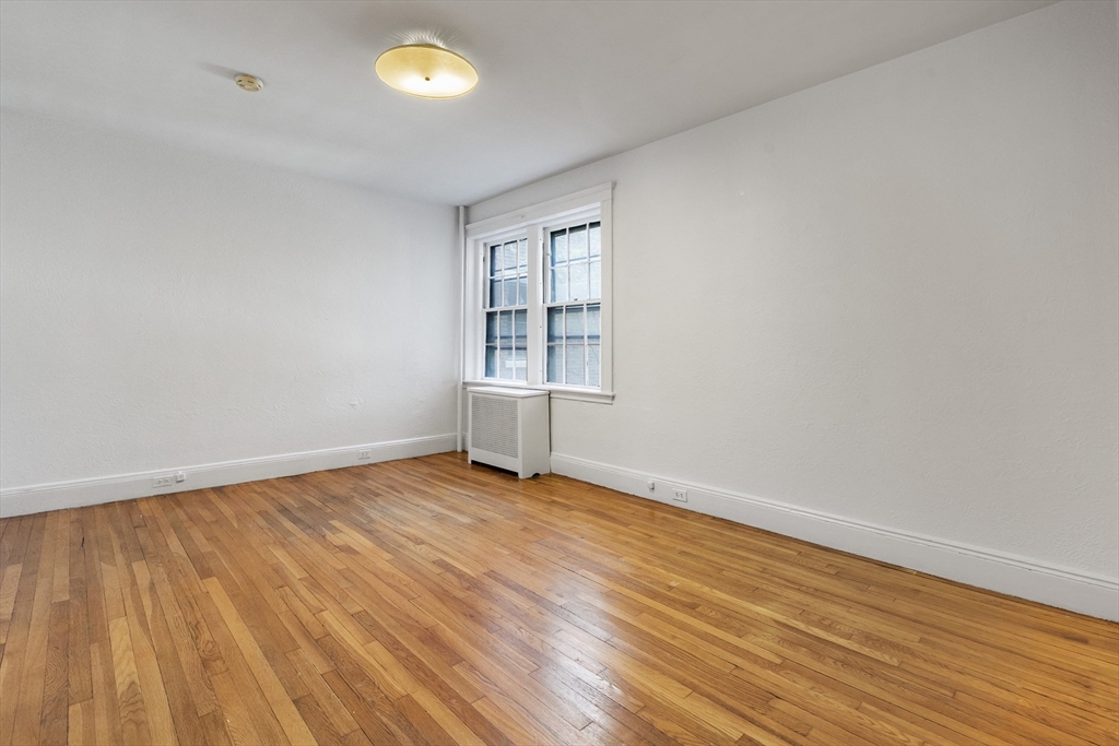 15-17 James Street, Unit 2 Brookline, MA 02446 - Photo 17 of 28 an empty room with wooden floor and windows