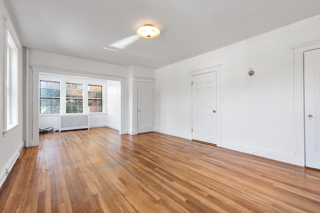 15-17 James Street, Unit 2 Brookline, MA 02446 - Photo 22 of 28 wooden floor in an empty room with a window