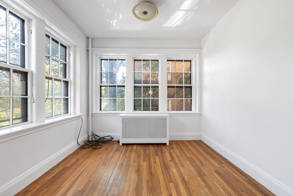 15-17 James Street, Unit 2 Brookline, MA 02446 - Photo 23 of 28 an empty room with wooden floor and windows