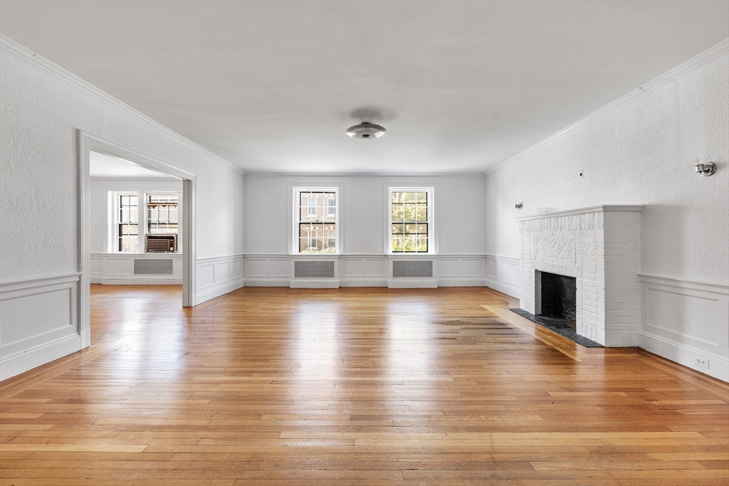 15-17 James Street, Unit 2 Brookline, MA 02446 - Photo 4 of 28 a view of a livingroom with wooden floor and a fireplace