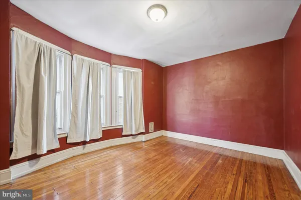 a view of a room with wooden floor and a window
