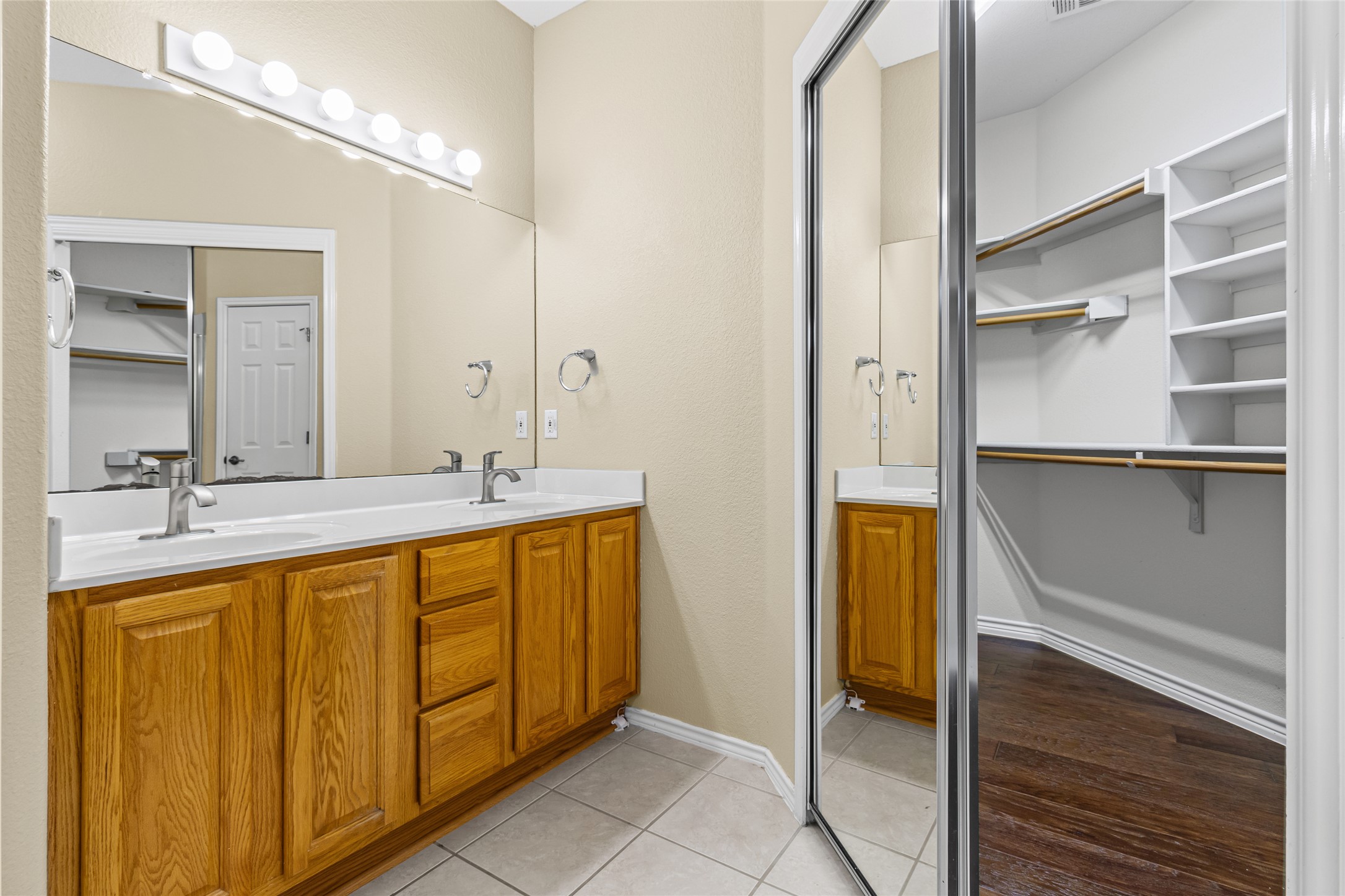 14901 Staked Plains Loop Austin, TX 78717 - Photo 18 of 30 Full bathroom featuring double vanity, a spacious closet, and light tile patterned floors