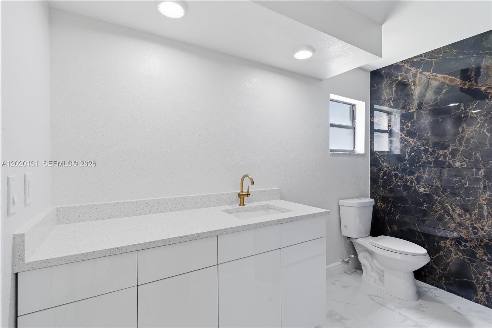 13408 Whitby Road Hudson, FL 34667 - Photo 10 of 30 a bathroom with a sink a toilet and a mirror
