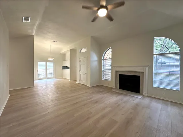 a view of an empty room with a fireplace and a window