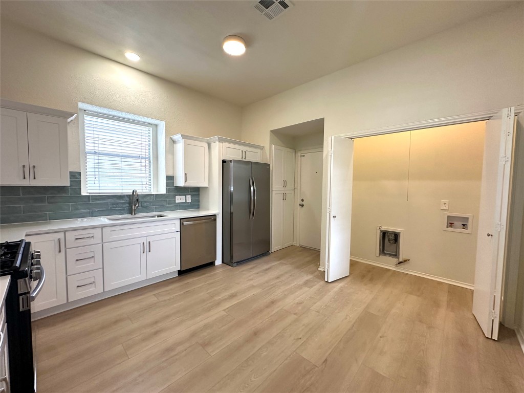 2105 Cervin Boulevard Austin, TX 78728 - Photo 7 of 22 a kitchen with stainless steel appliances granite countertop a refrigerator a sink and white cabinets