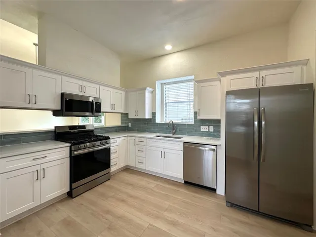 a kitchen with a sink stove and refrigerator