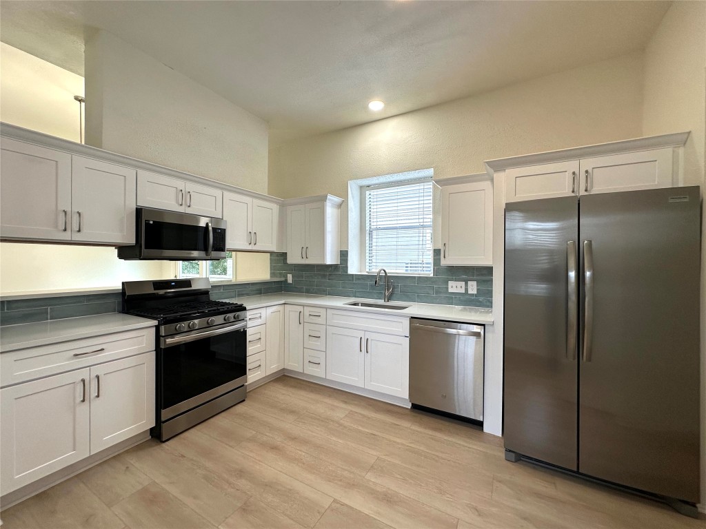 2105 Cervin Boulevard Austin, TX 78728 - Photo 8 of 22 a kitchen with a sink stove and refrigerator