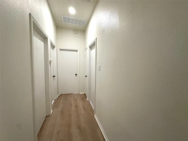a view of a hallway with wooden floor