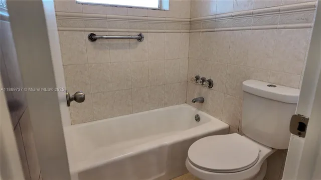 a white toilet sitting next to a bath tub
