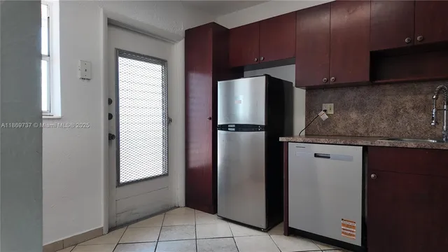 a kitchen with stainless steel appliances granite countertop a refrigerator and a sink