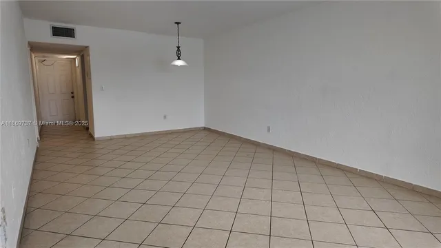 an empty room with white walls and tiles
