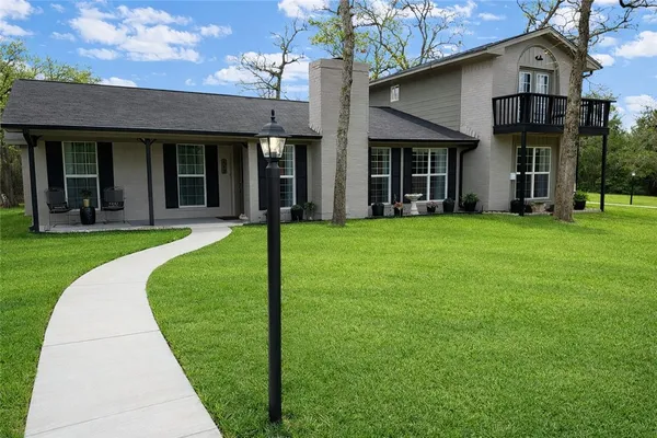 front view of a brick house with a yard