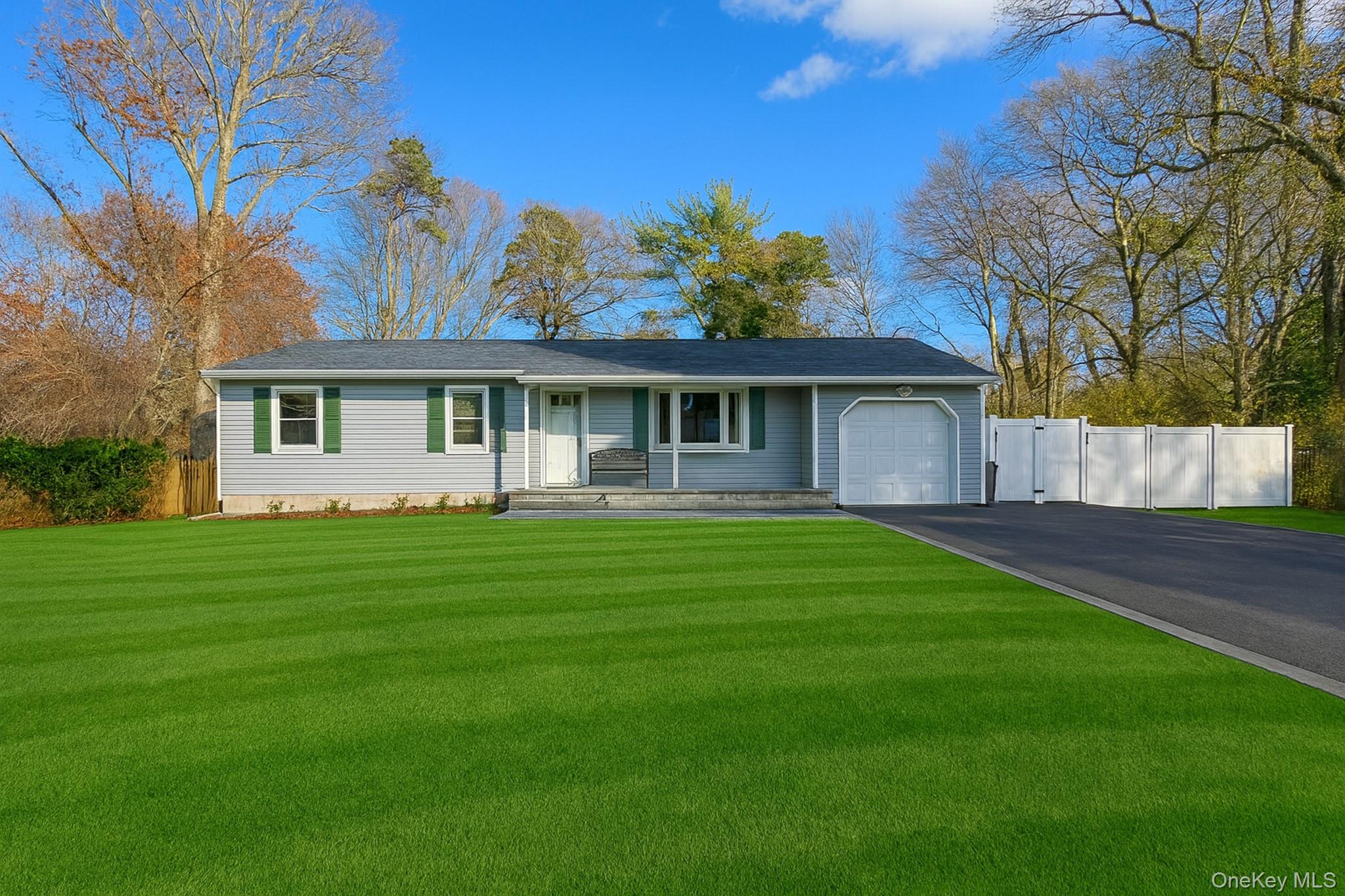 a view of a white house with a big yard and potted plants